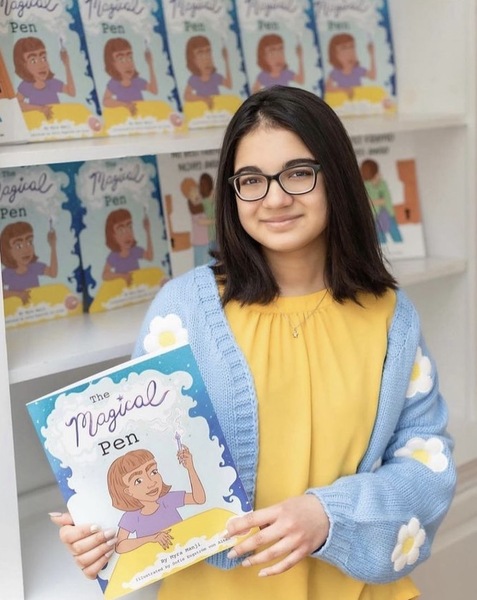 Myra Manji holding her book The Magical Pen