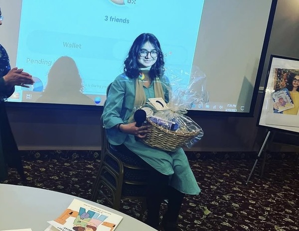 Myra at speaking event with gift basket
